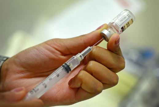 person injecting something into a bottle