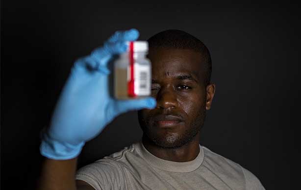 male holding a urine sample